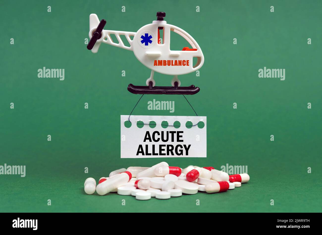 Medical concept. On a green surface, an ambulance helicopter, pills and ...