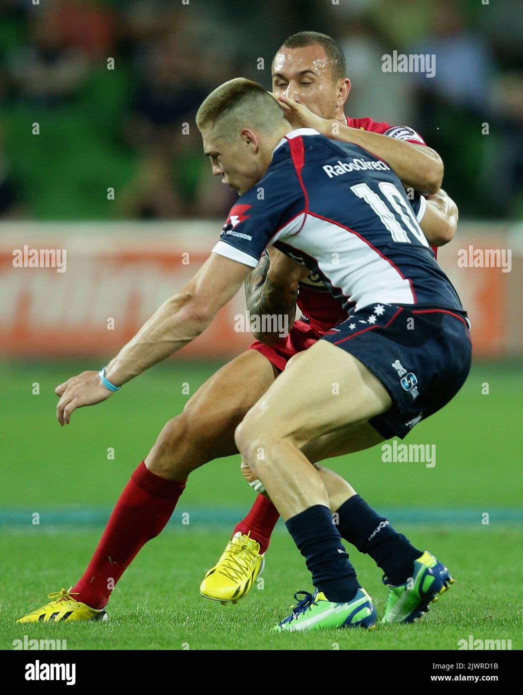 Quade Cooper of the Reds attempts to sidestep James O'Connor of ...