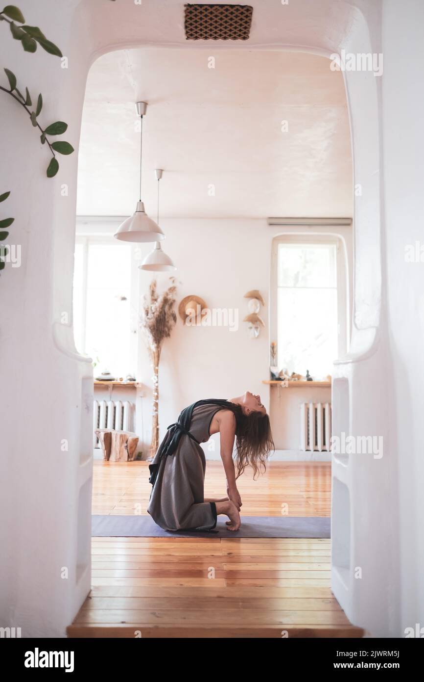 Yogi caucasian woman practicing yoga lesson, doing ushtrasana or camel pose Stock Photo