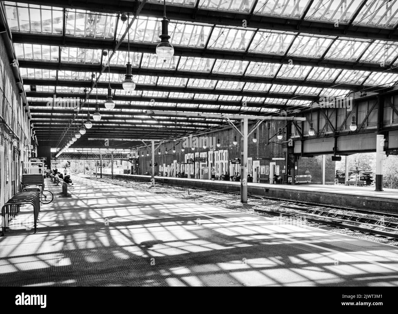The interior of Stoke on Trent Station, with a pattern of shadows tom the roof reflected on the platform Stock Photo
