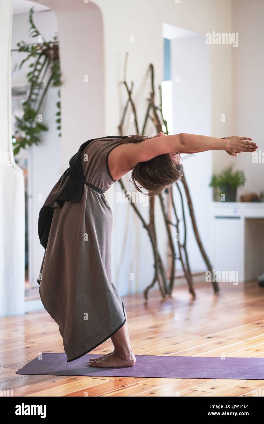 Yogi caucasian woman practicing yoga lesson, doing hastauttanasana or upward salute bending spine Stock Photo