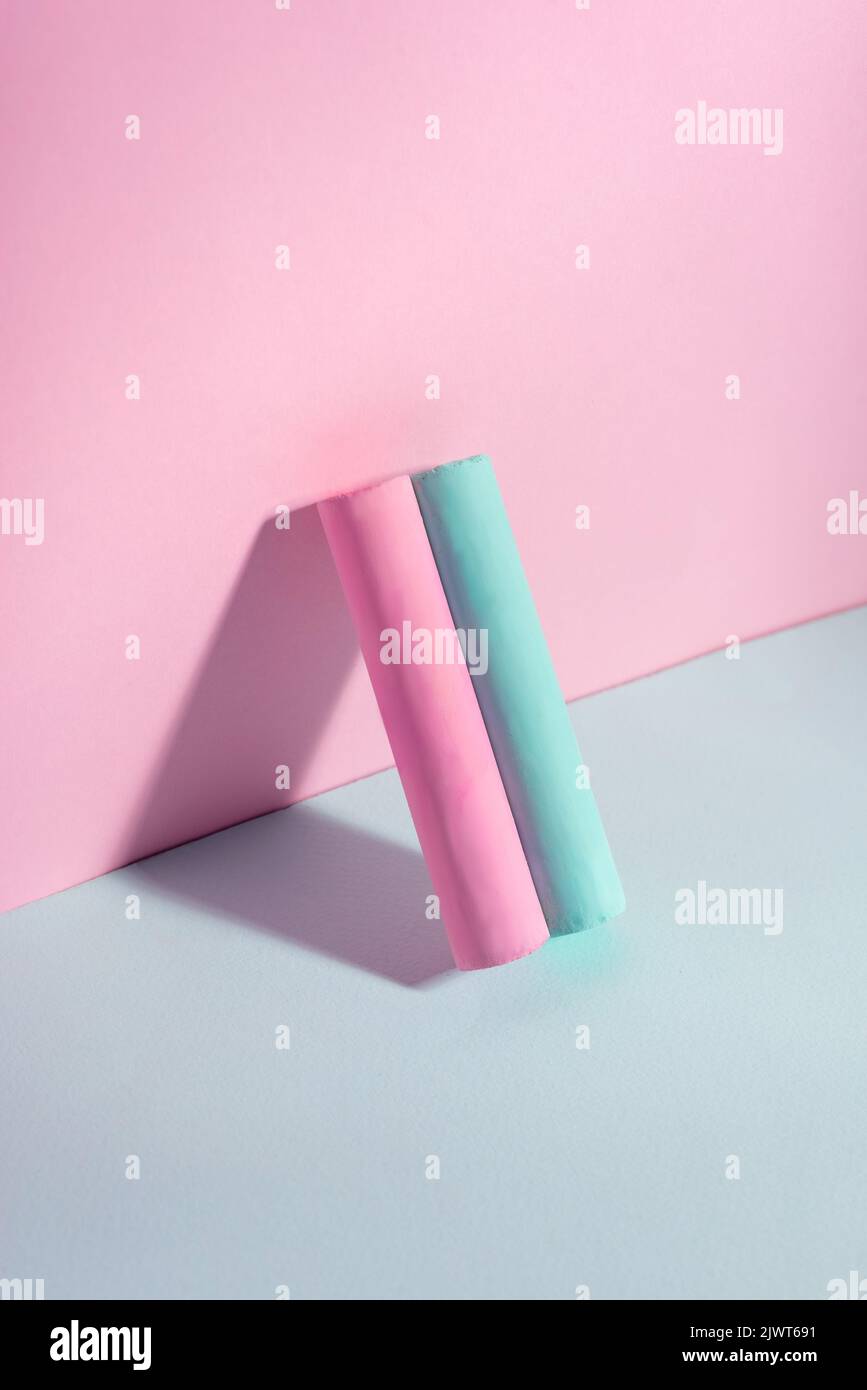 blue pink cylindrical chalk on pink blue background minimal Stock Photo