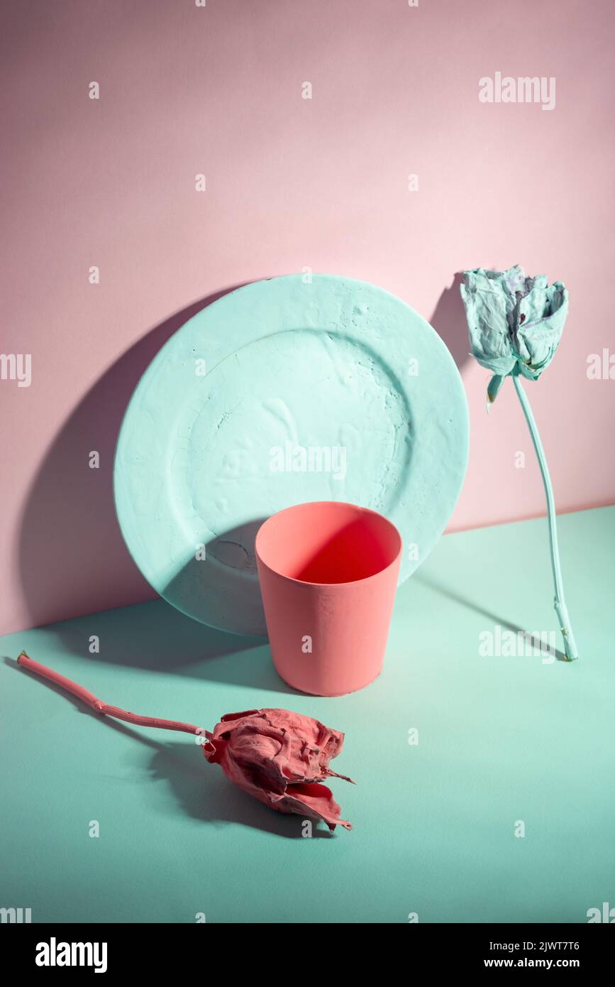 green and living coral color minimalist still life of dishes and roses painted Stock Photo