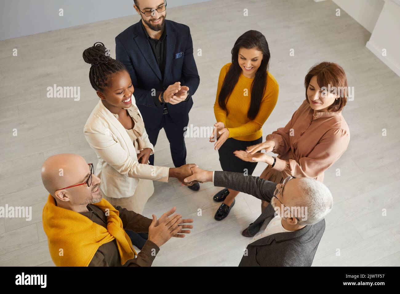 Smiling diverse businesspeople handshake close deal Stock Photo