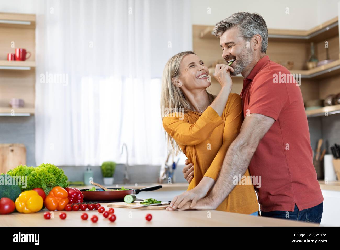 Happy middle aged spouses preparing delicious dinner together Stock Photo
