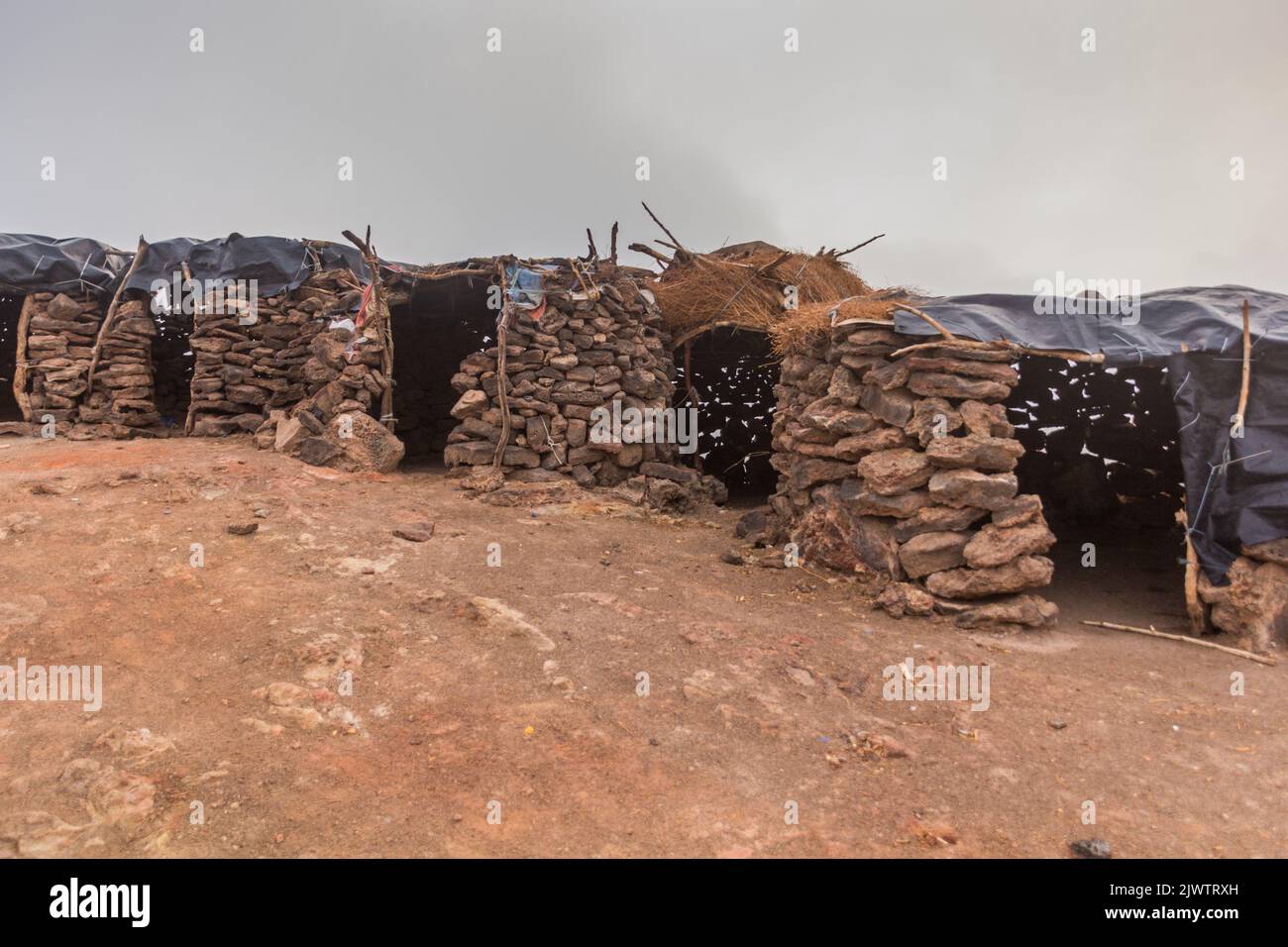 Stone huts at Erta Ale volcano crater rim in Afar depression, Ethiopia Stock Photo