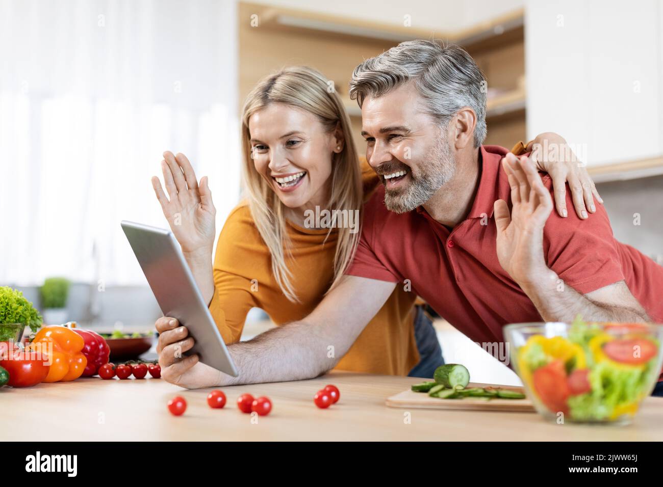 Happy man and woman using digital tablet while cooking Stock Photo