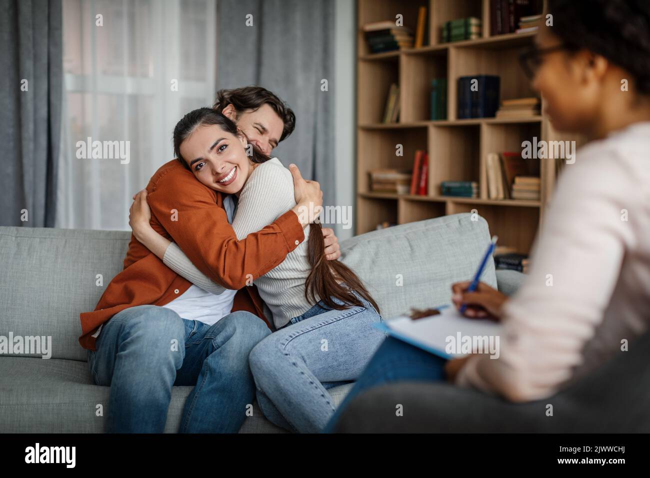 Glad Millennial European Male And Female Hugging At Meeting With