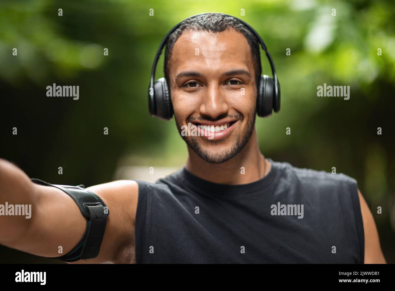 Happy black guy taking selfie while exercising at park Stock Photo