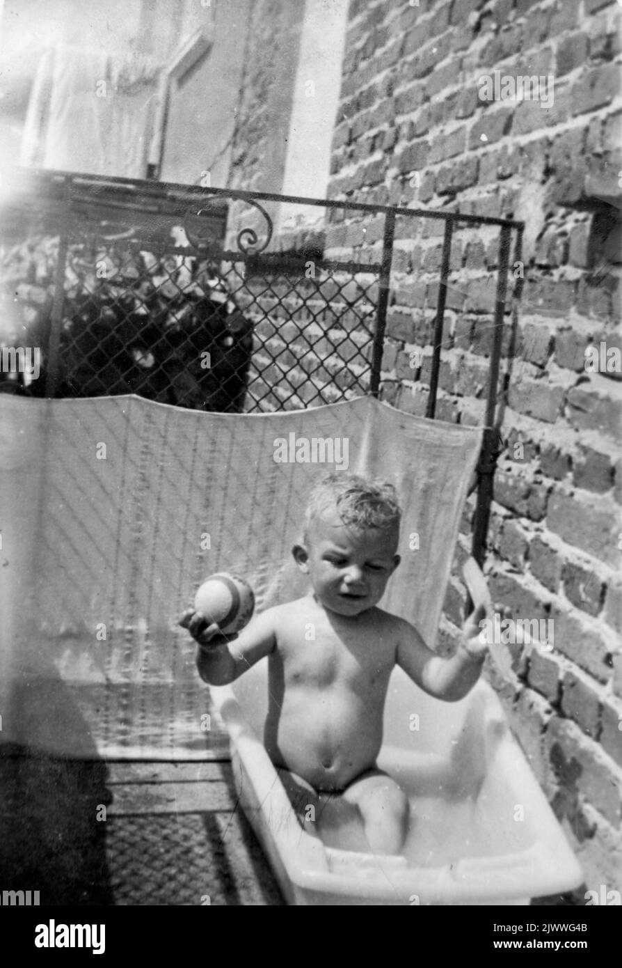 Black and white portrait of 2 years old boy having a bath in a bathtub outdoors on a balcony, late 60s, Bulgaria, Europe, Balkans Stock Photo