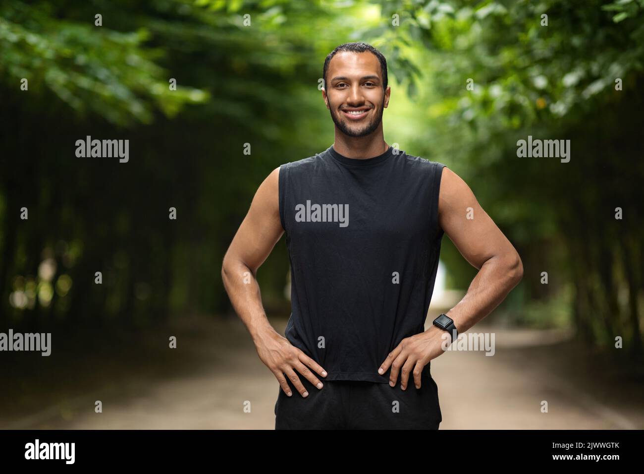 Handsome athletic guy jogging in public park Stock Photo