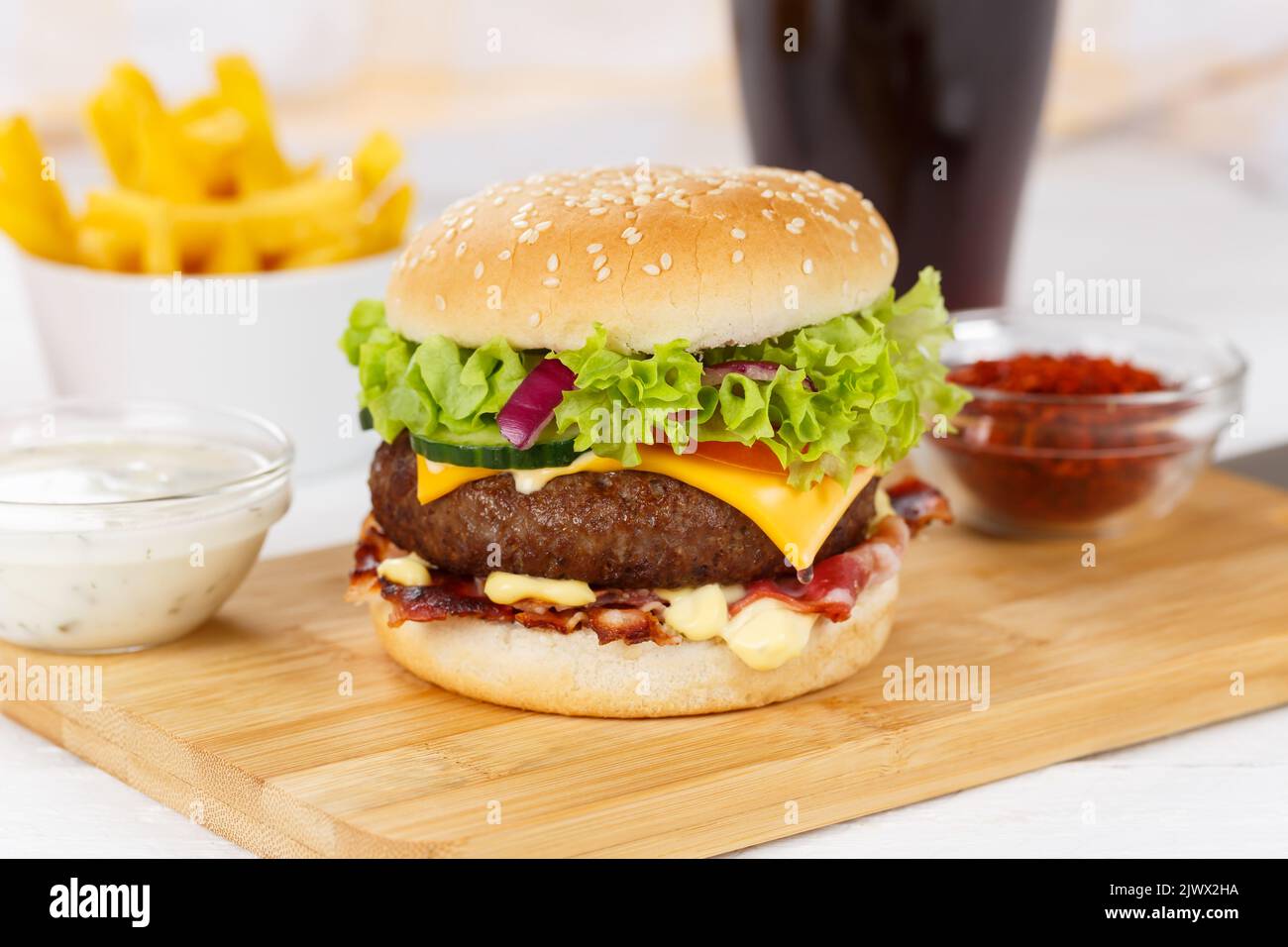 Hamburger Cheeseburger meal fastfood fast food with cola drink and French Fries on a wooden board menu Stock Photo