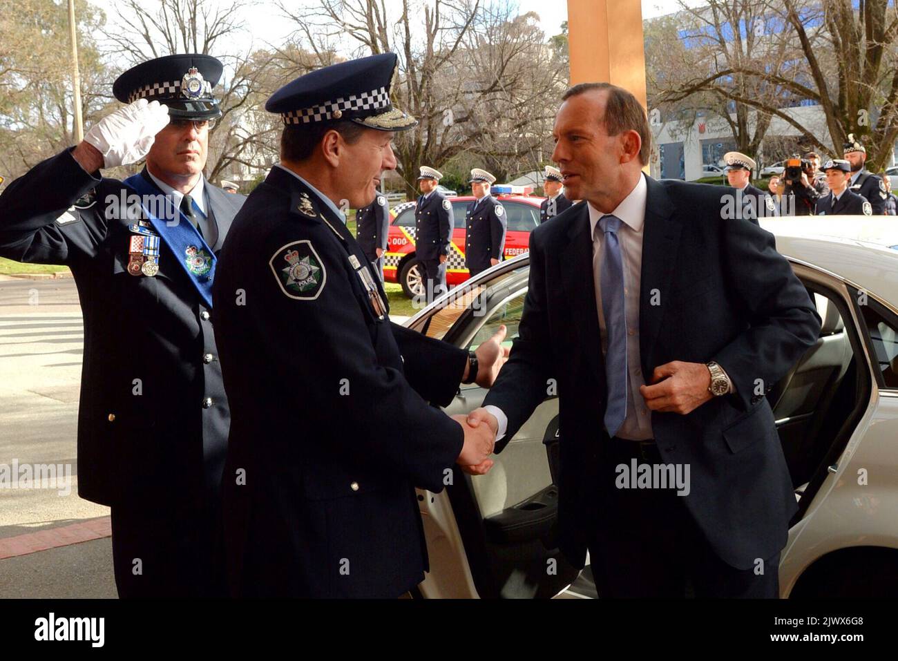 Prime Minister Tony Abbott is greeted by Australian Federal Police Commissioner Tony Negus as he arrives for an AFP graduation parade in Canberra, Thursday, June 26, 2014. (AAPImage/Alan Porritt) Stock Photo