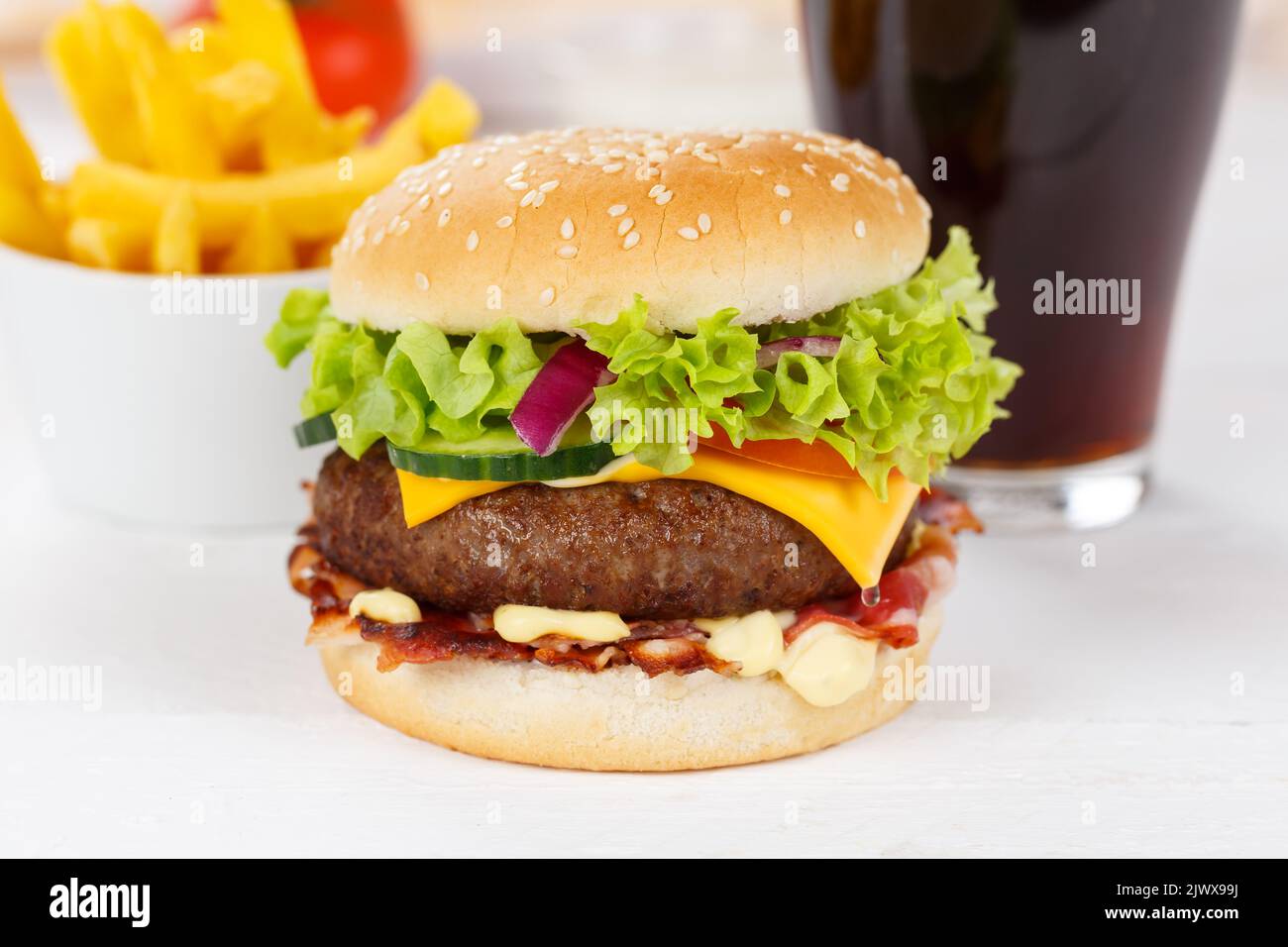 Hamburger Cheeseburger meal fastfood fast food with cola drink and French Fries on a wooden board menu Stock Photo