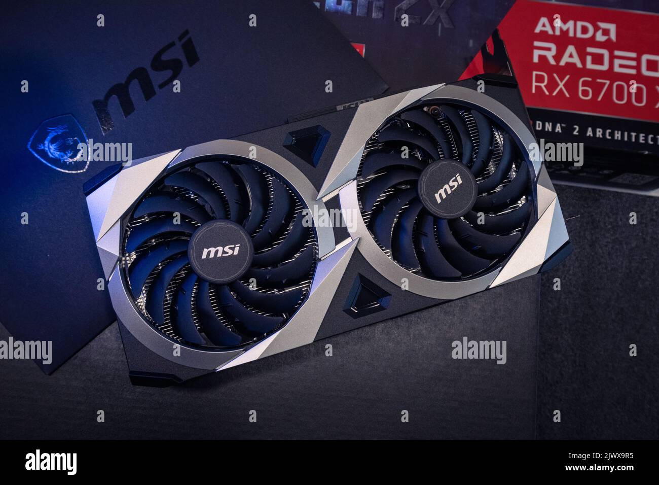 Kyiv, Ukraine - August 19, 2022: MSI MECH 2X graphics video card with AMD Radeon RX6700XT chipset unboxing in blue light, close-up with box Stock Photo