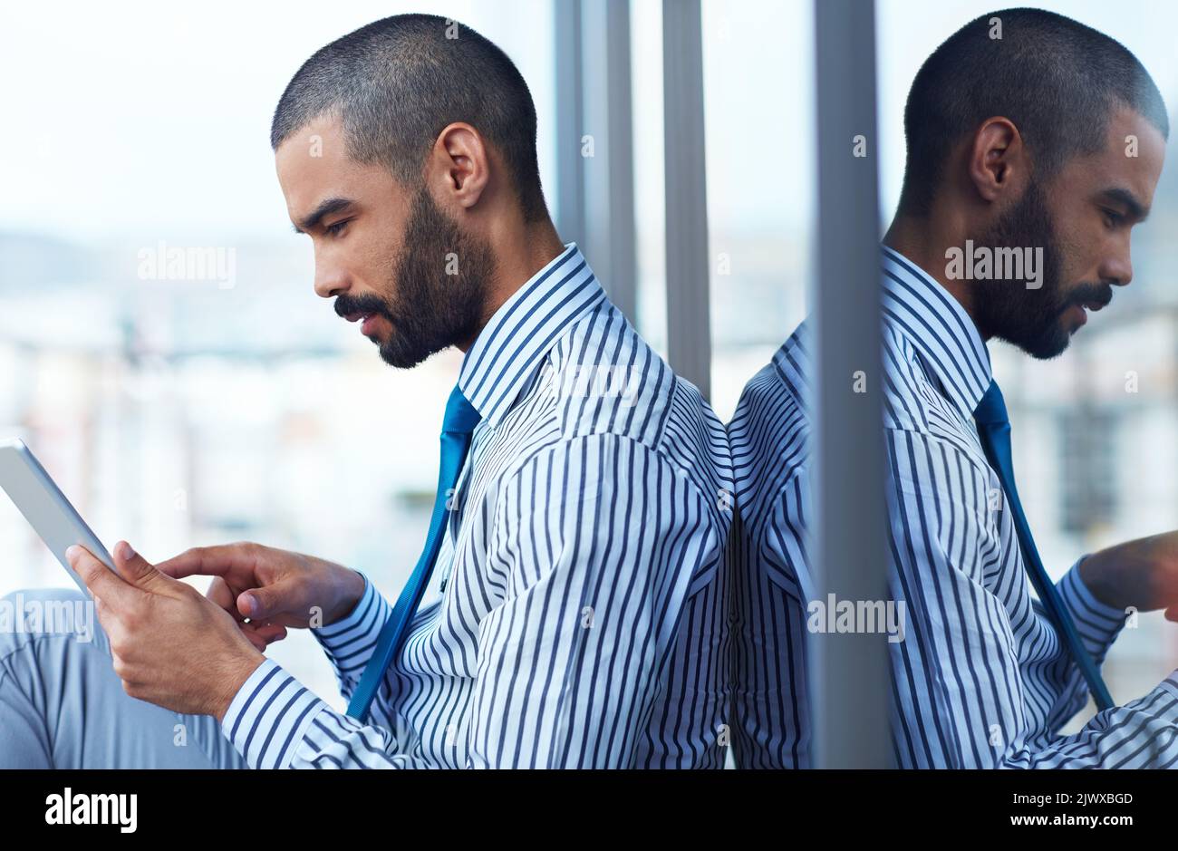 Installing a new corporate app. a young businessman using a digital tablet outside of an office building. Stock Photo