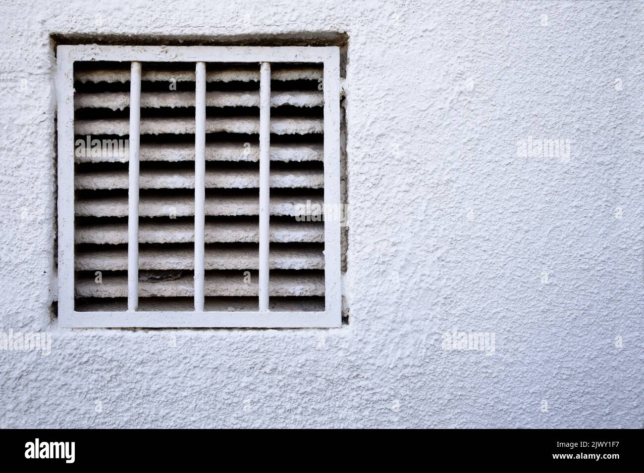 Detail of a wall decorated with white gotelé in which there is a service fireplace. Image with copy space Stock Photo