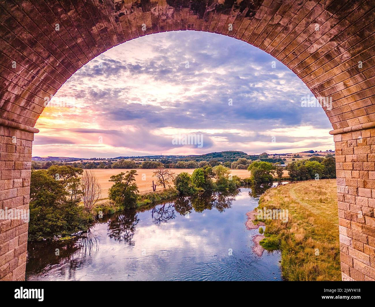 Aerial view through an arch of Arthington Viaduct upriver on River Wharfe Stock Photo