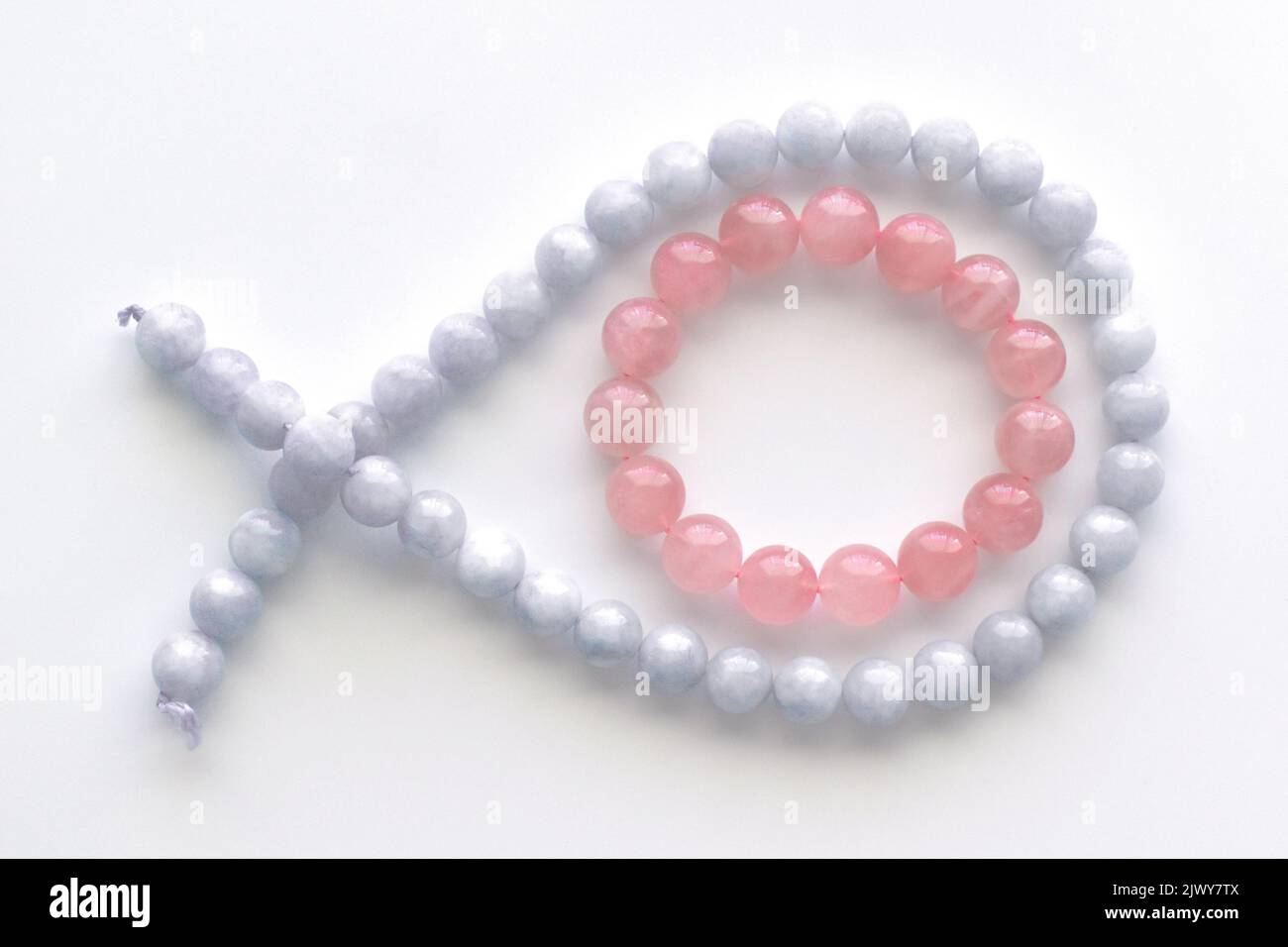 Rose quartz bracelet and aquamarine strand on the table. Stock Photo