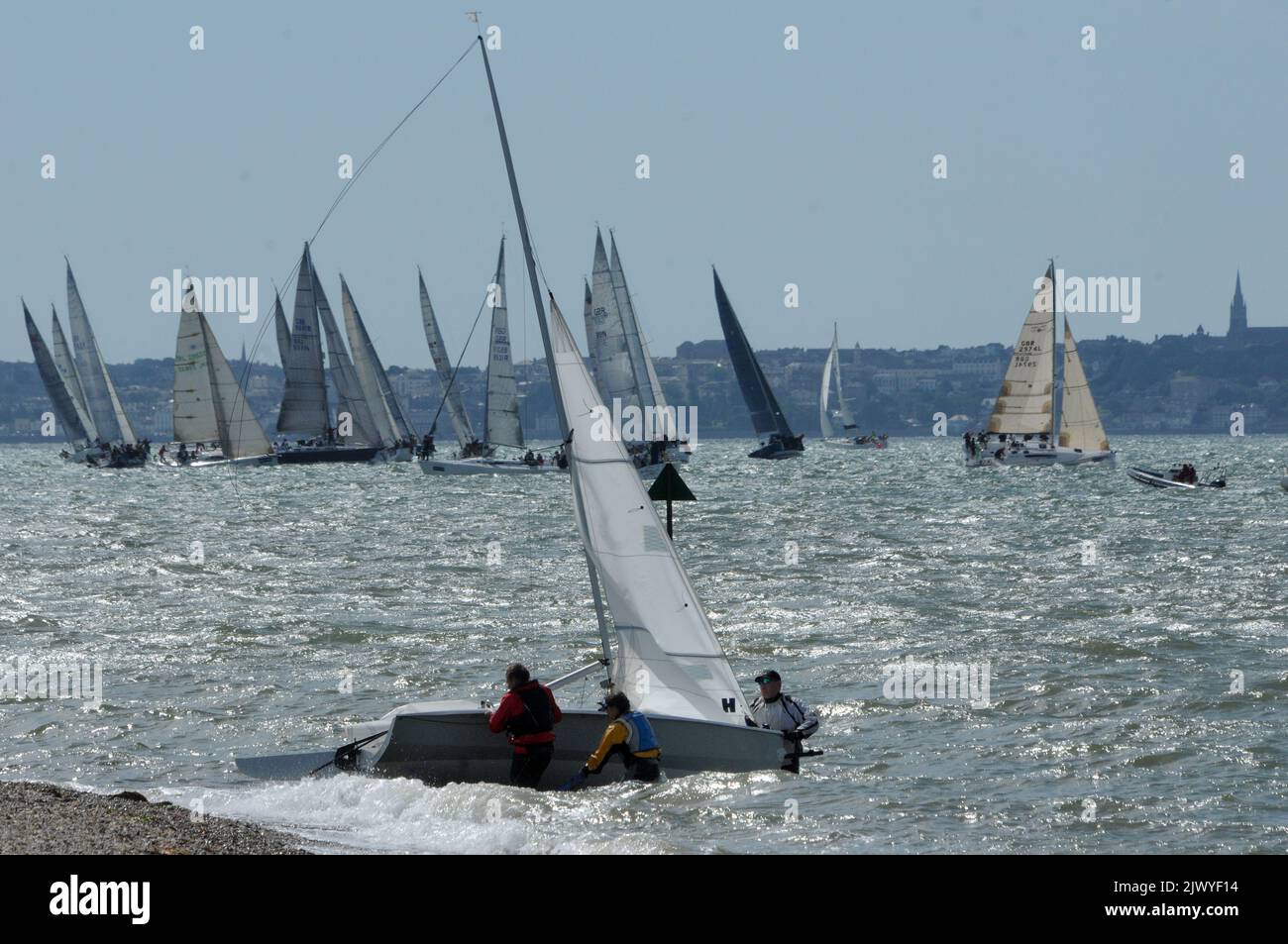 DINGHY SAILORS BEACH THEIR YACHT AS THE BIG BOYS TAKING PART IN COWES WEEK  BATTLE FOR POSITION CLOSE TO THE SHORE AT LEE ON THE SOLENT, HAMPSHIRE. PIC MIKE WALKER, MIKE WALKER PICTURES 2013 Stock Photo