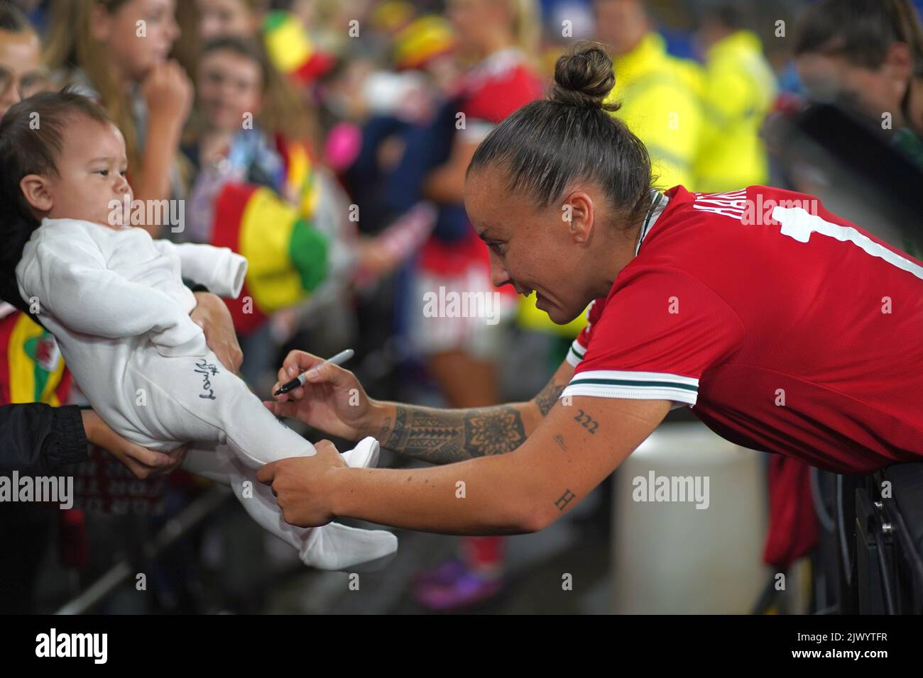 Cardiff, Wales, UK. 6th September, 2022. Natasha Harding autographs a baby as Wales Women Football Team celebrate a nil-nil draw against Slovenia to qualify for the World Cup Play offs. Cardiff City STadium, Cardiff. Credit: Penallta Photographics/Alamy Live News Stock Photo