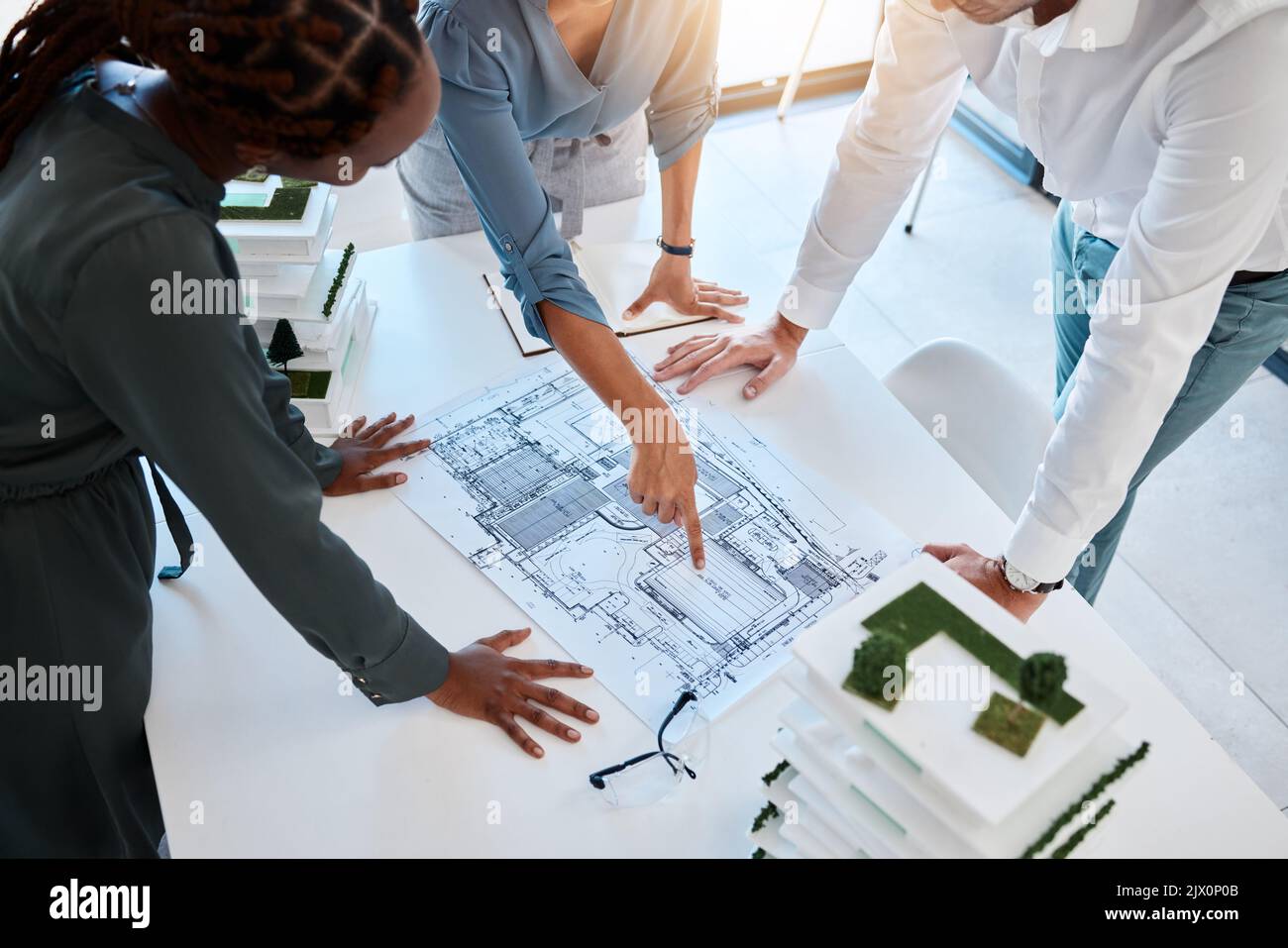 Architect, team and planning building blueprint in office for coworkers to look at before