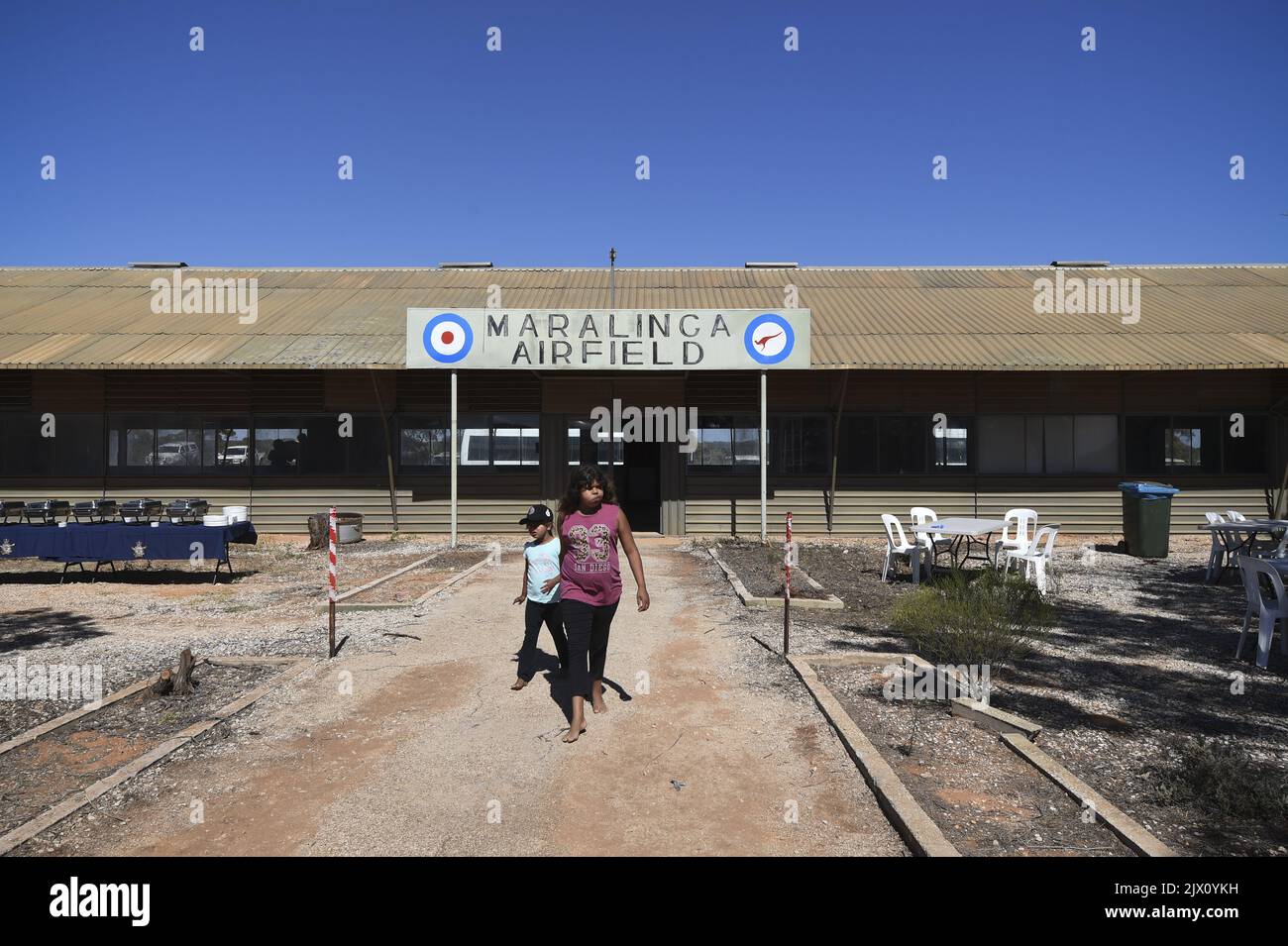 Aboriginal children walk near the Maralinga Airfield terminal during a
