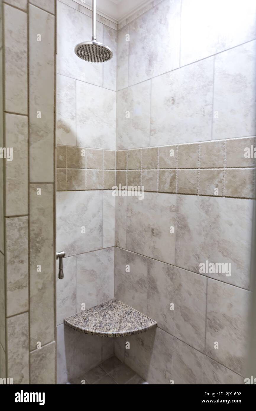 an empty and tiled gray and beige shower in a guest bathroom. Stock Photo
