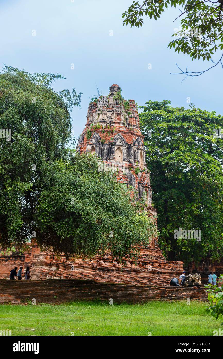 Dilapidated, crumbling red brick prang leaning and in danger of collapse in the ruins at Wat Maha That, the sacred royal temple in Ayutthaya, Thailand Stock Photo