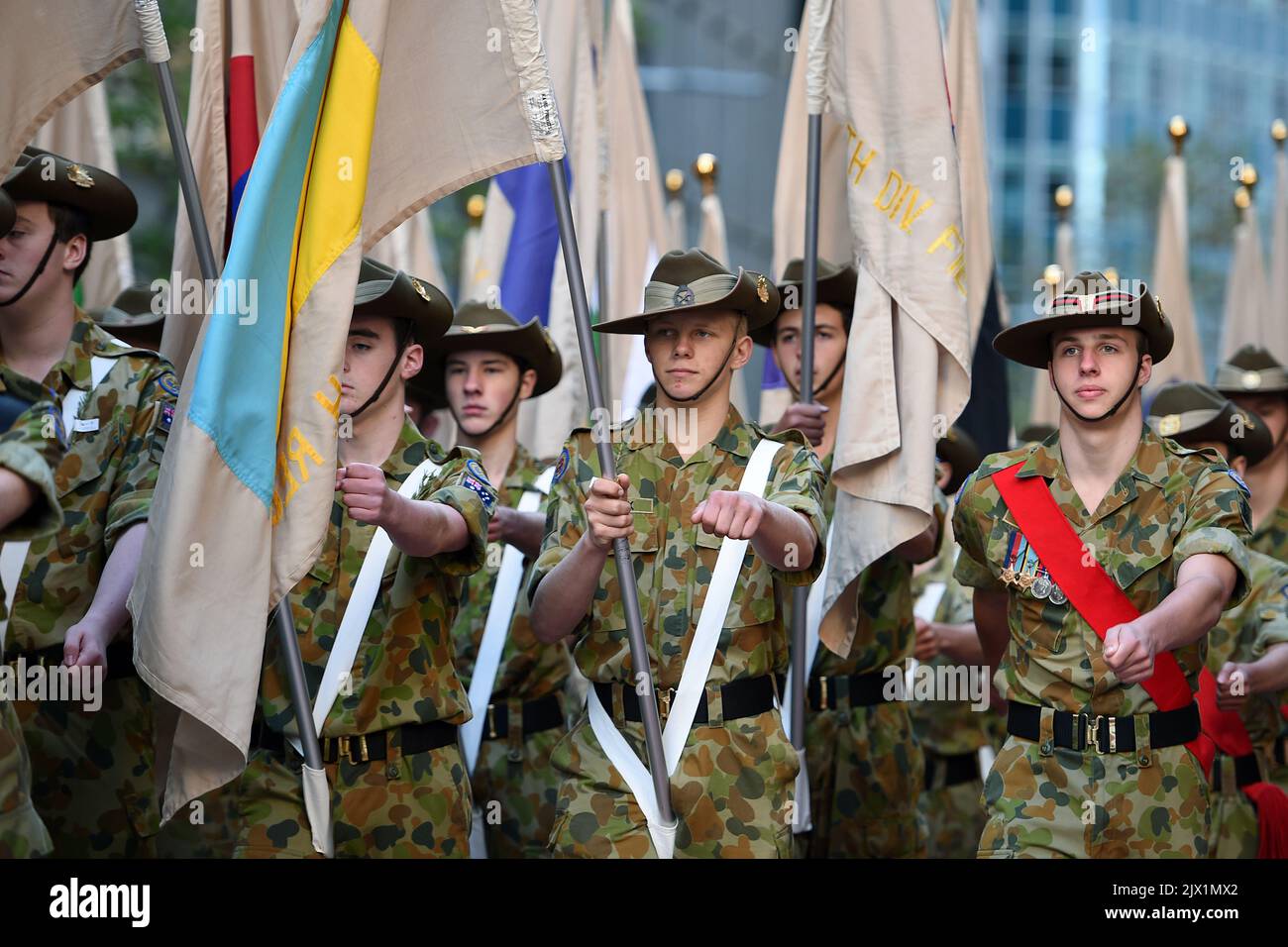 Australian Army cadets carry flags bearing the insignia of WWI units ...