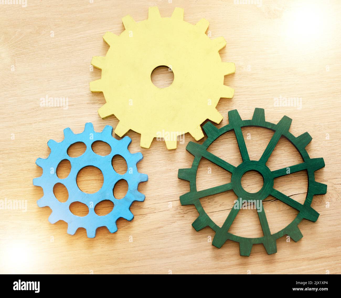 Collaboration, engineering and construction concept with industrial gears, mechanics and cogs on a table or desk in an office. Teamwork, synergy and Stock Photo