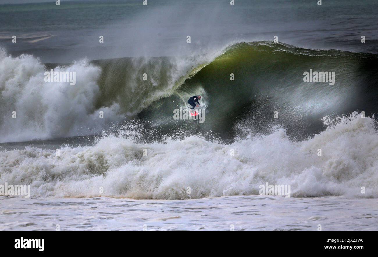 A surfer makes the most of the big swell off Narrabeen beach in Sydney ...
