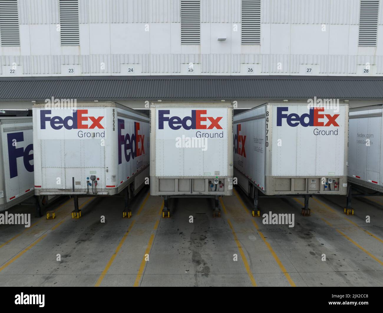 A closeup view of FedEx transport trailers while docked at a Federal Express shipping terminal; the FedEx logo is seen on each trailer. Stock Photo