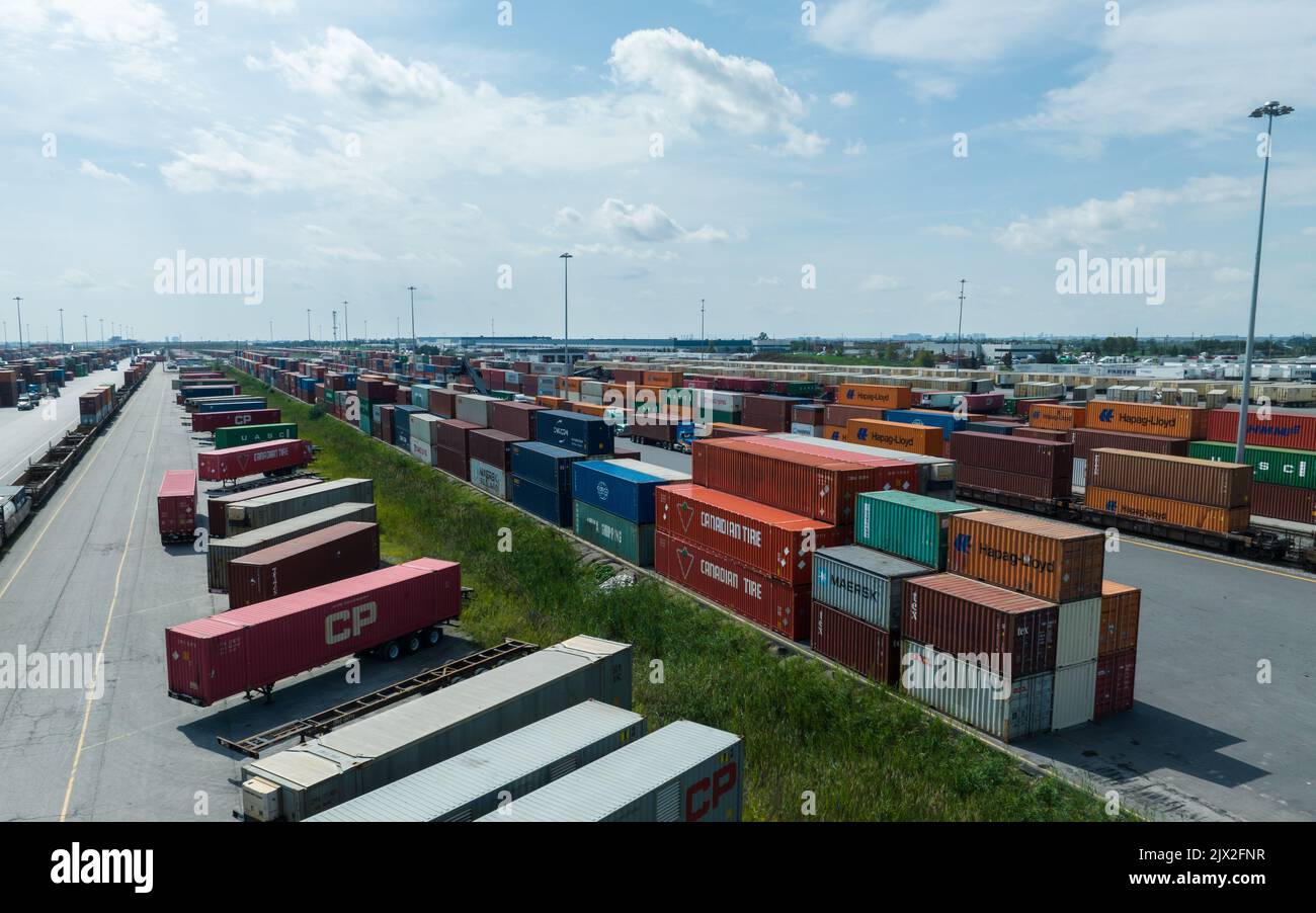 A high-angle aerial photo above a vast shipping container terminal, yard. Seen on a partly cloudy, sunny day. Stock Photo