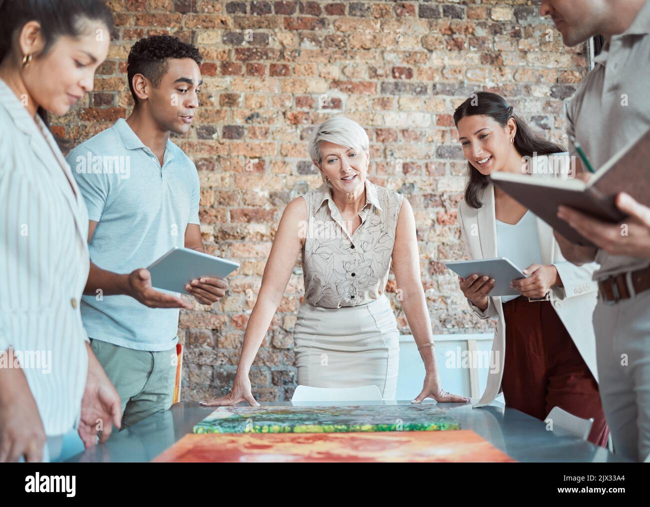 Team of art workers talking in meeting with painting, planning