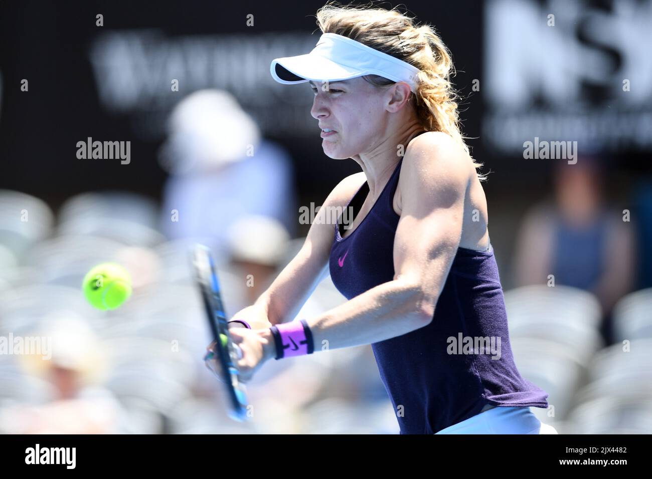 Eugene Bouchard of Canada returns a shot to Shaui Zhang of China during