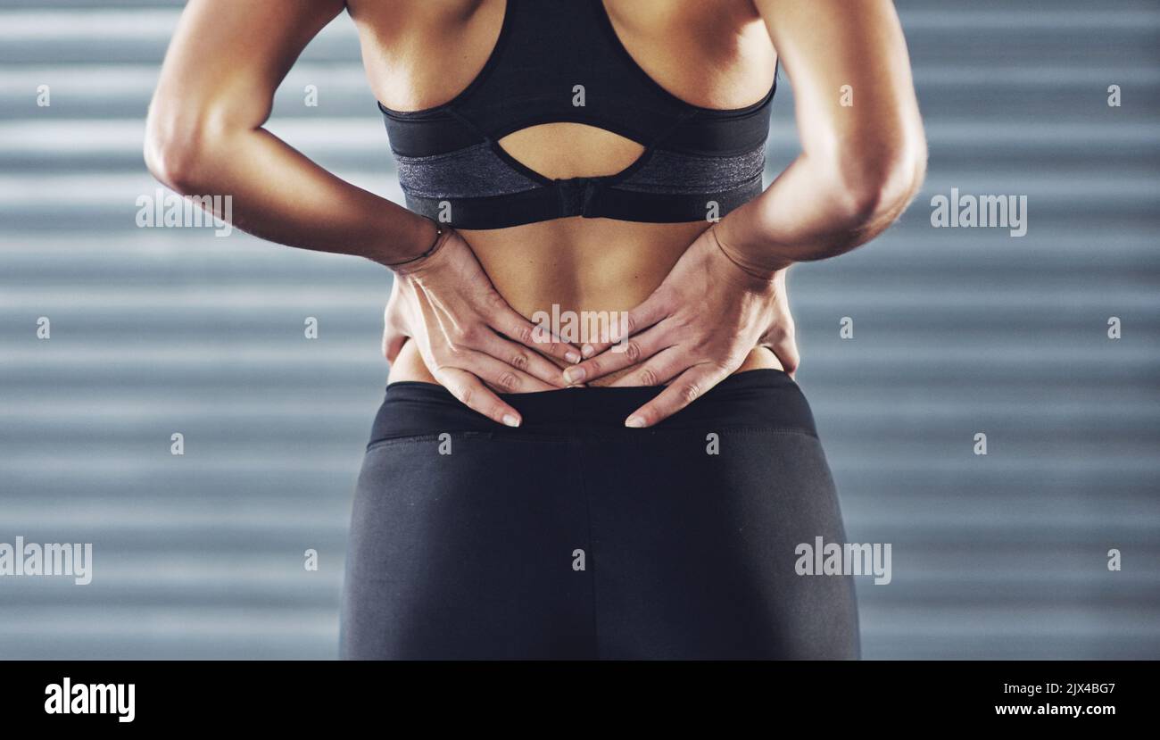The hazard of a hard workout. a sportswoman with a lower back injury