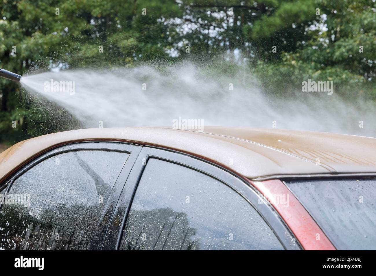 A man cleaning car with washing car under high pressure jet spraying