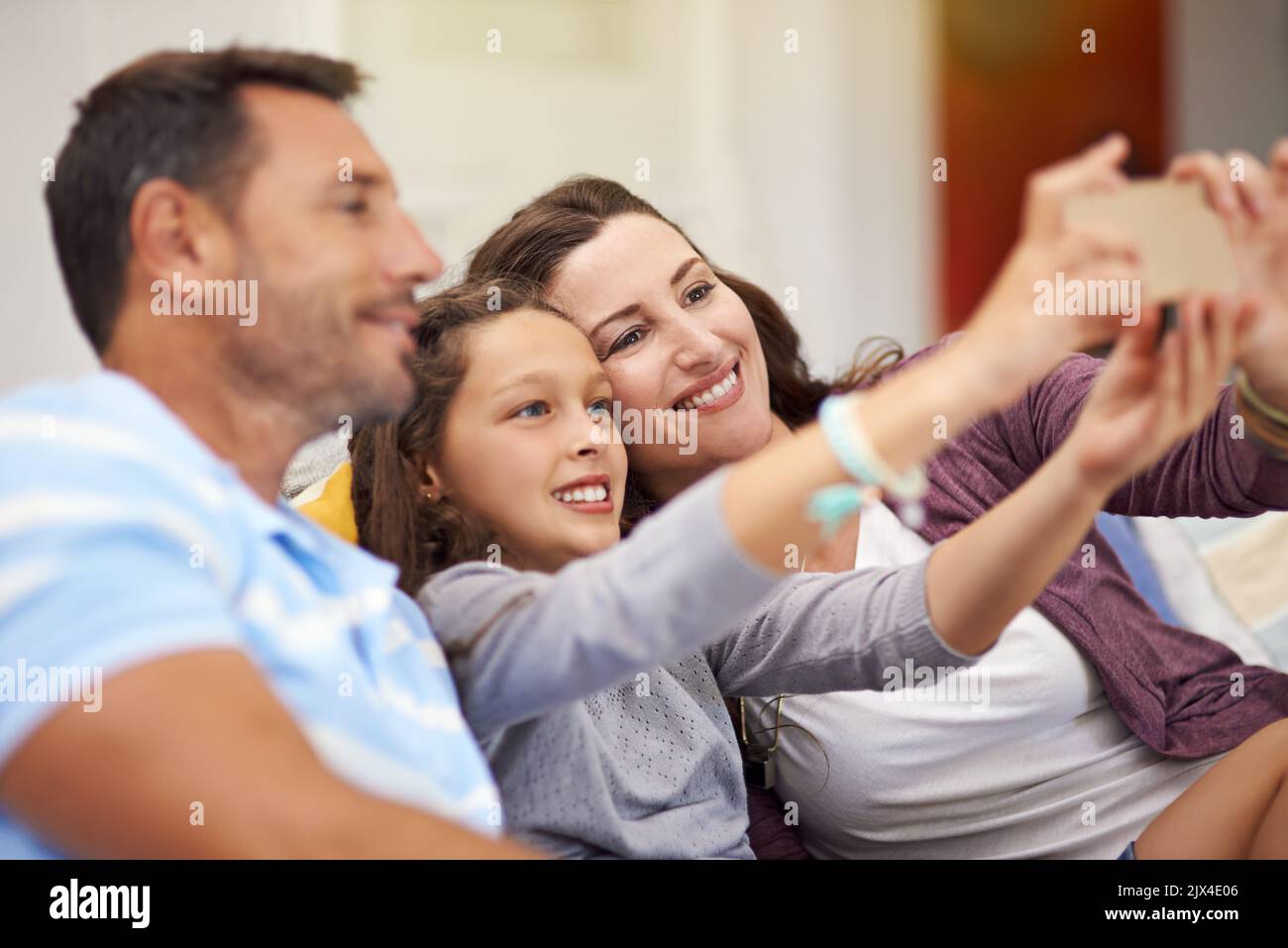 Big smiles everyone. a family sitting on the sofa at home. Stock Photo