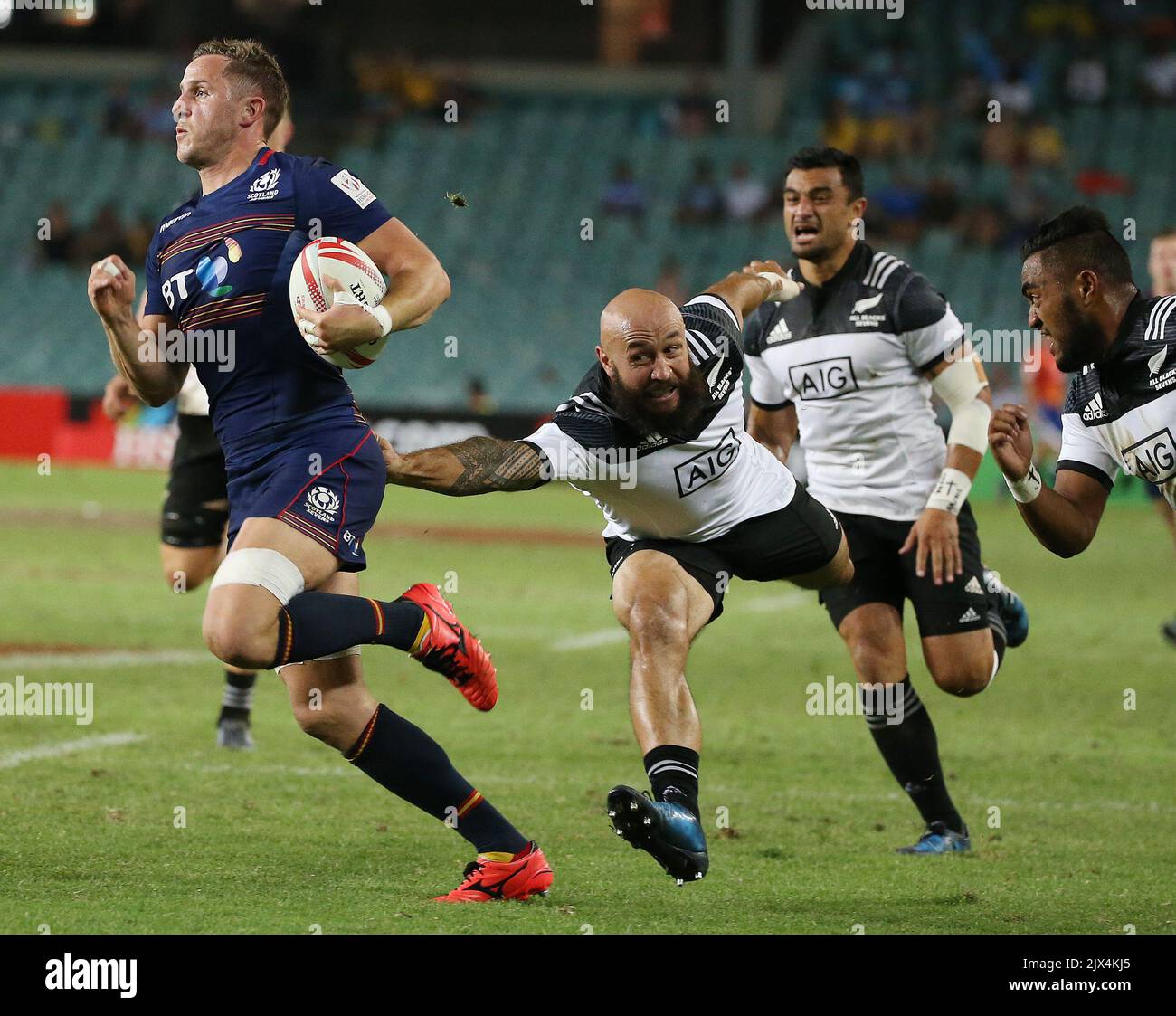 DJ Forbes of New Zealand (right) grabs hold of the shirt of Mark Robertson  of Scotland as he runs with the ball during their Men's Pool C match at the  Sydney Rugby
