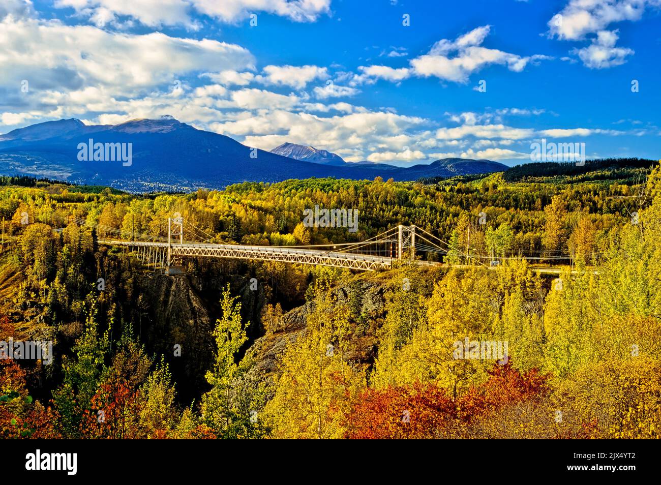 A beautiful fall landscape of the suspension bridge crossing the Bulkley River at Hazelton British Columbia Canada. Stock Photo