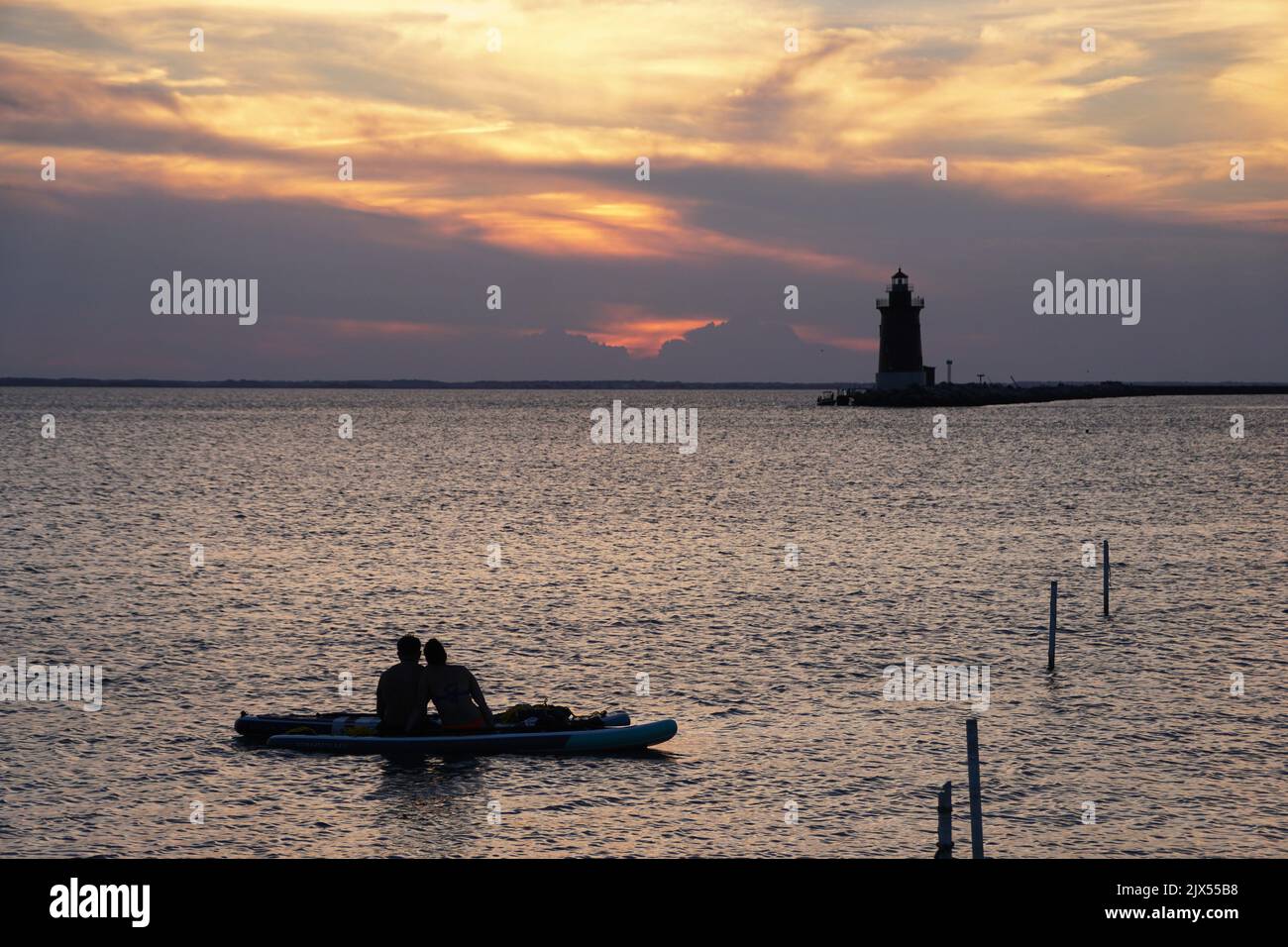 Silhouette of a couple enjoying sunset from a kayak at Cape Henlopen State Park, Lewes, Delaware, U.S.A Stock Photo