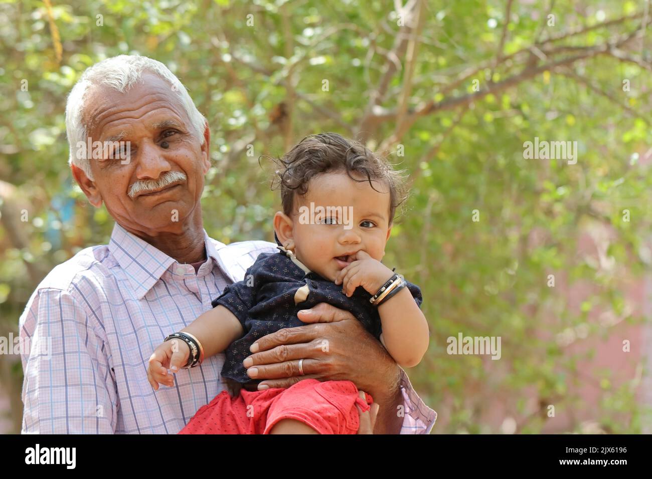 Close-up Photo together with little grand son in the dock in Indian Hindu grandfather garden Stock Photo