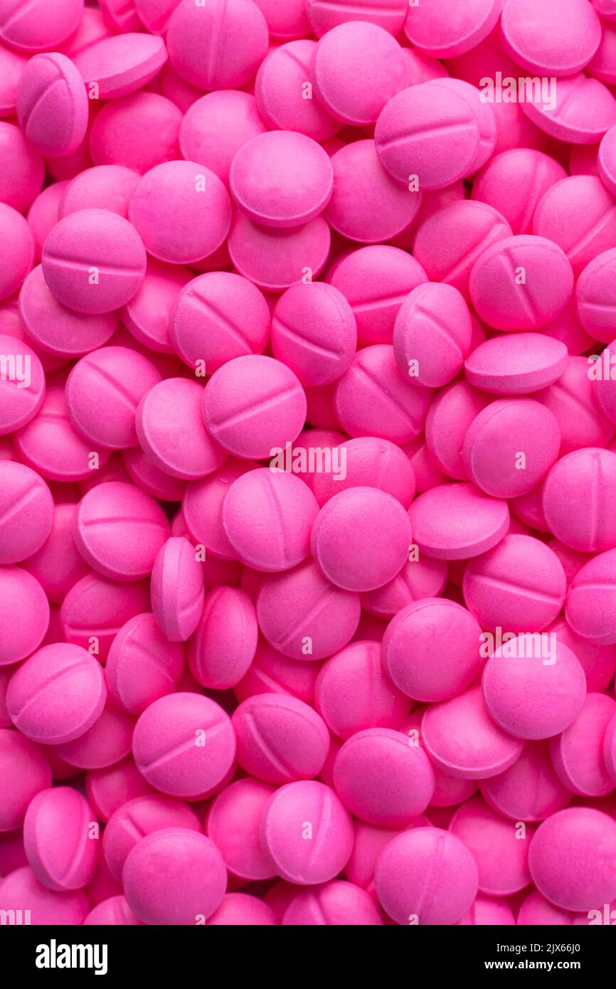 pile of pink round pills or tablets, medical drugs taken straight from above, full frame background close-up Stock Photo
