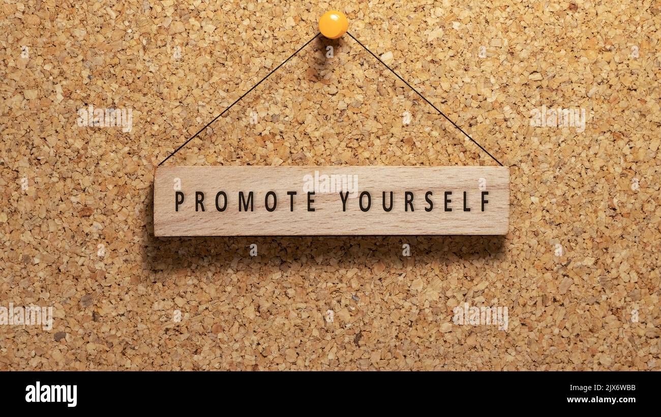 Promote Youself word promote yourself written on wooden surface. Hanging on wooden ...