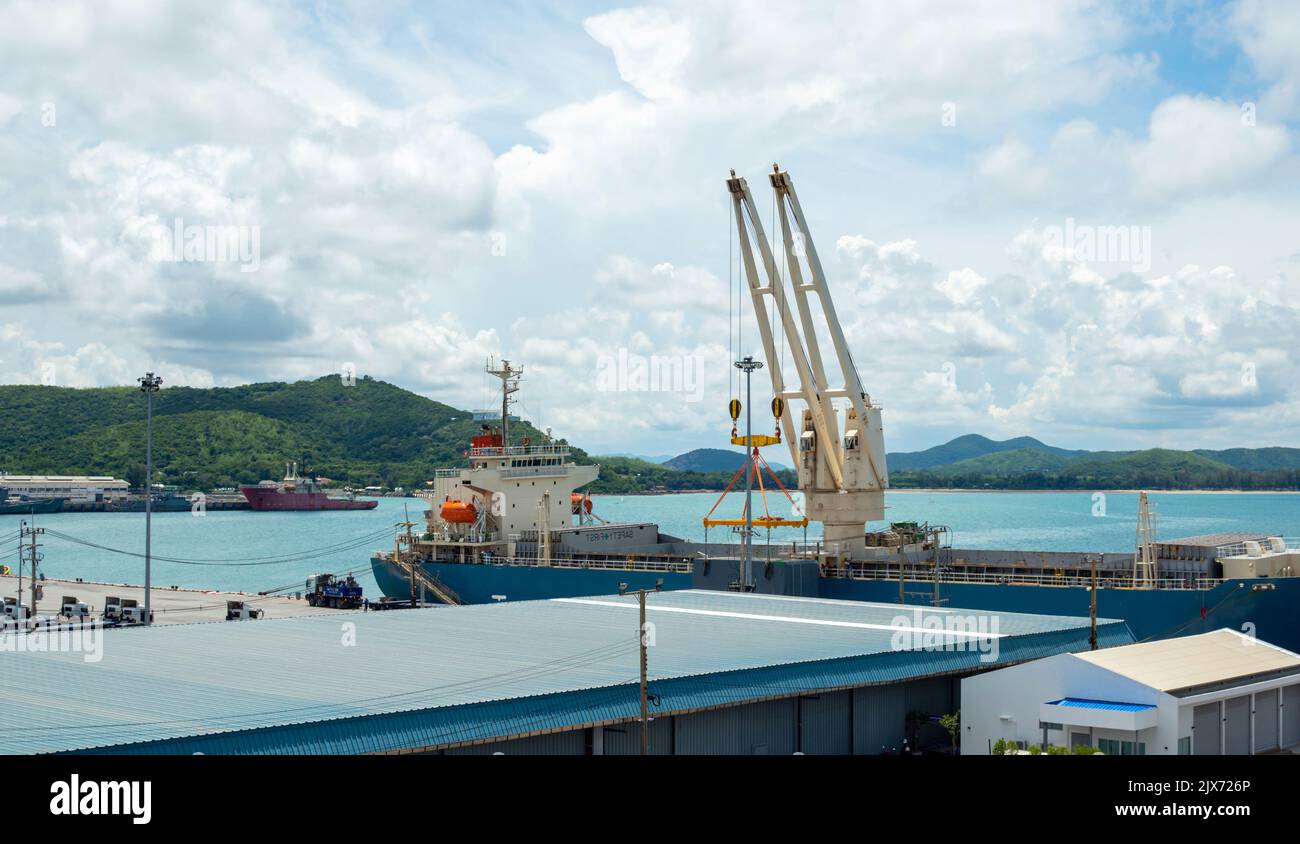 Industrial port crane lift up loading export containers box onboard at port of Thailand. Stock Photo