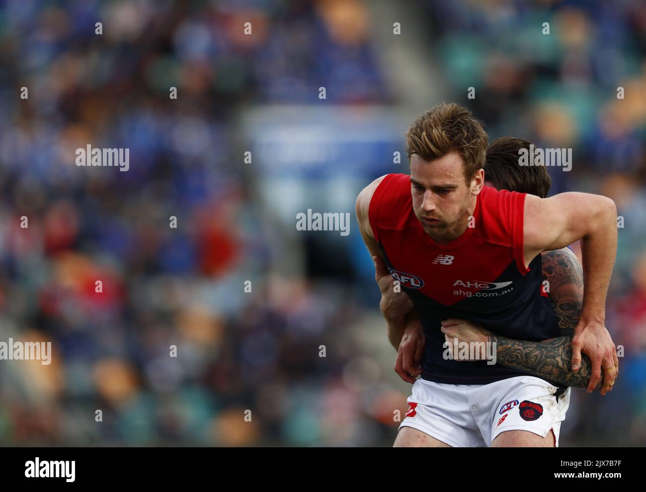 Dom Tyson of the Demons is held during the round 19 AFL match