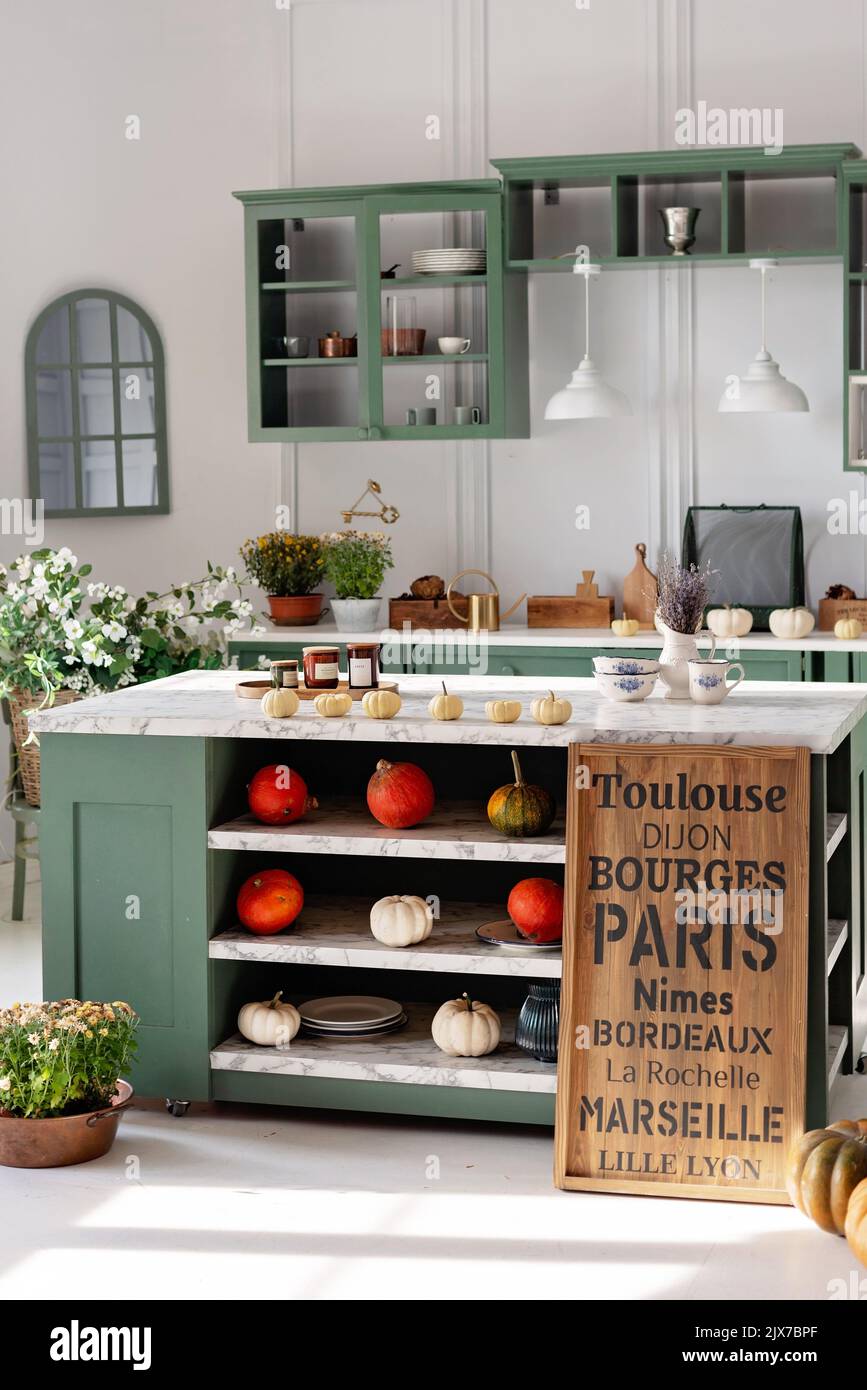 Kitchen with green vintage furniture, marble countertop with flowers