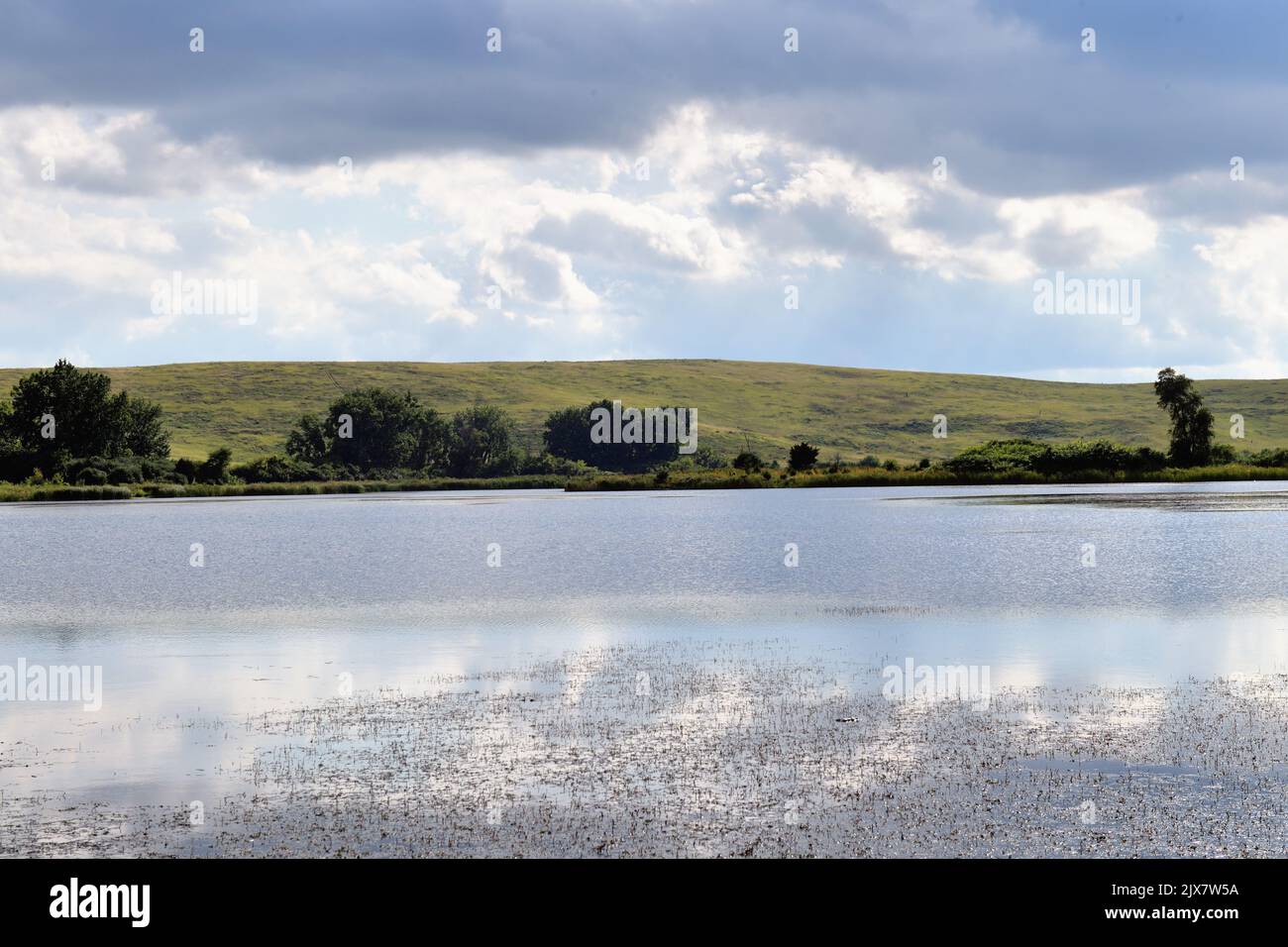 Bloomingdale, Illinois, USA. A small lake sits below a completed landfill project that has become part of a restored and preserved setting. Stock Photo