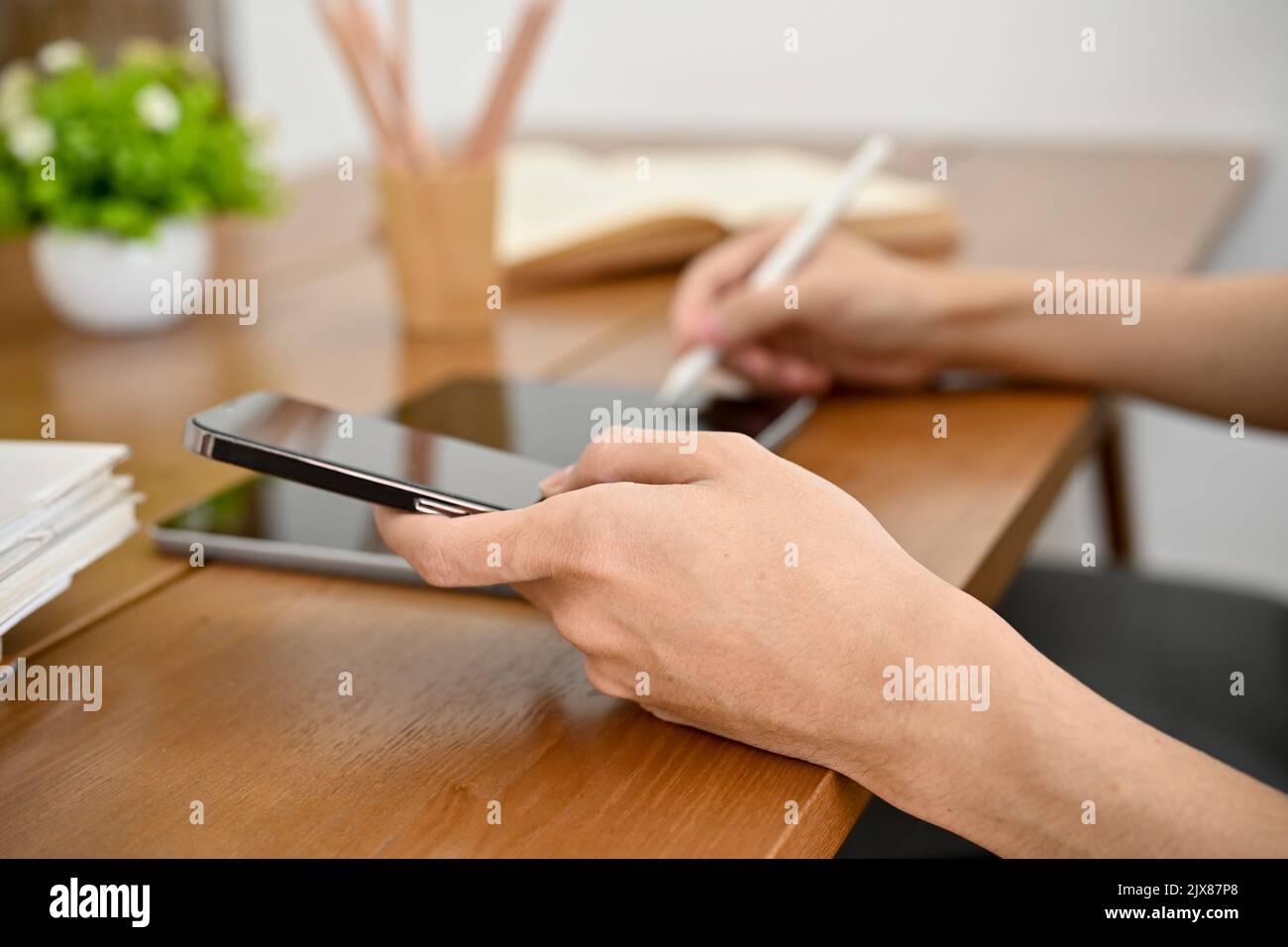 A man using digital tablet and smartphone to manage his tasks. holding